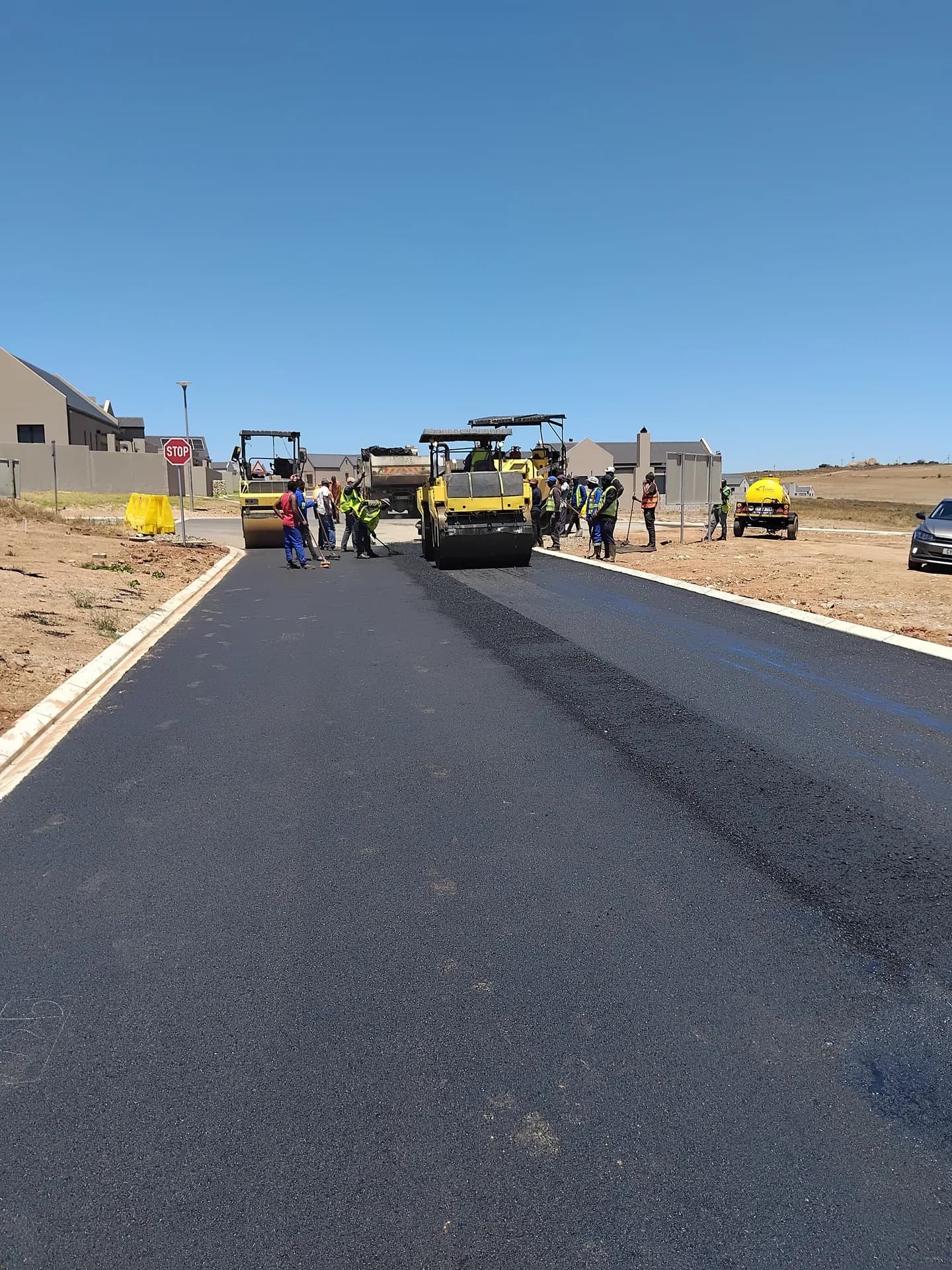 Asphalt paver and crew on a new residential street