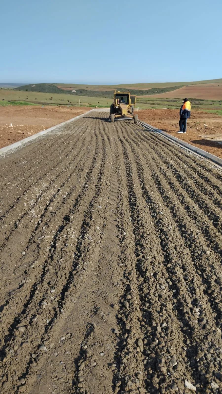 Precision grading of a road base