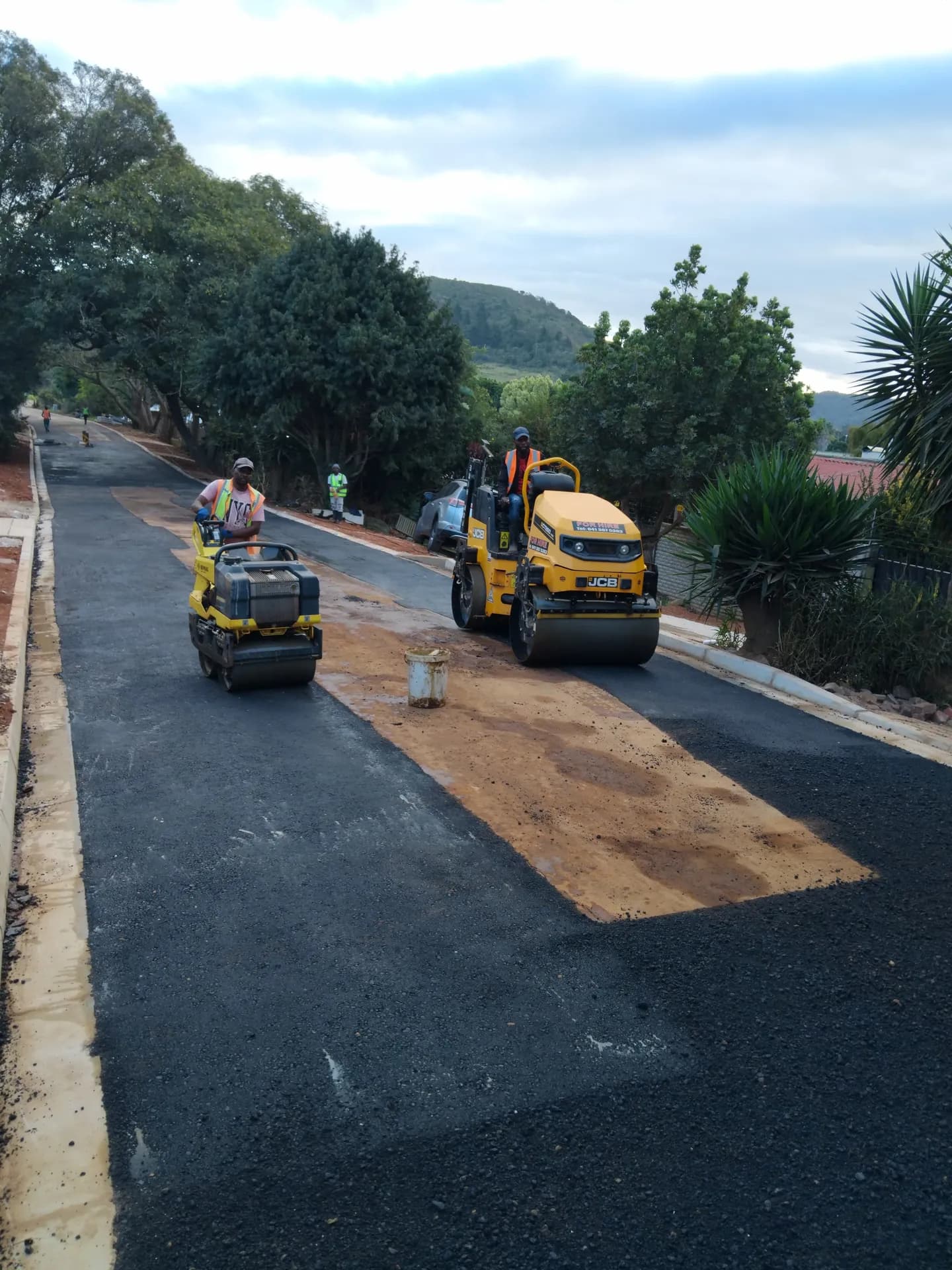 Rollers surfacing a new street between kerbs