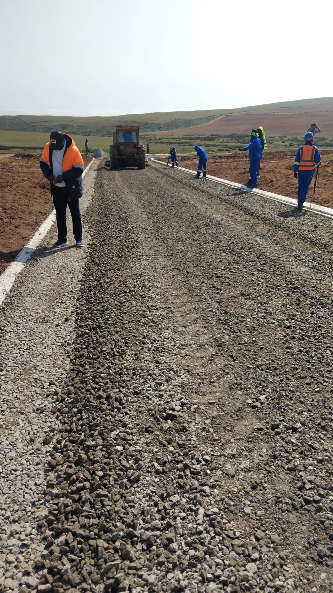 Stone layer spread ahead of surfacing