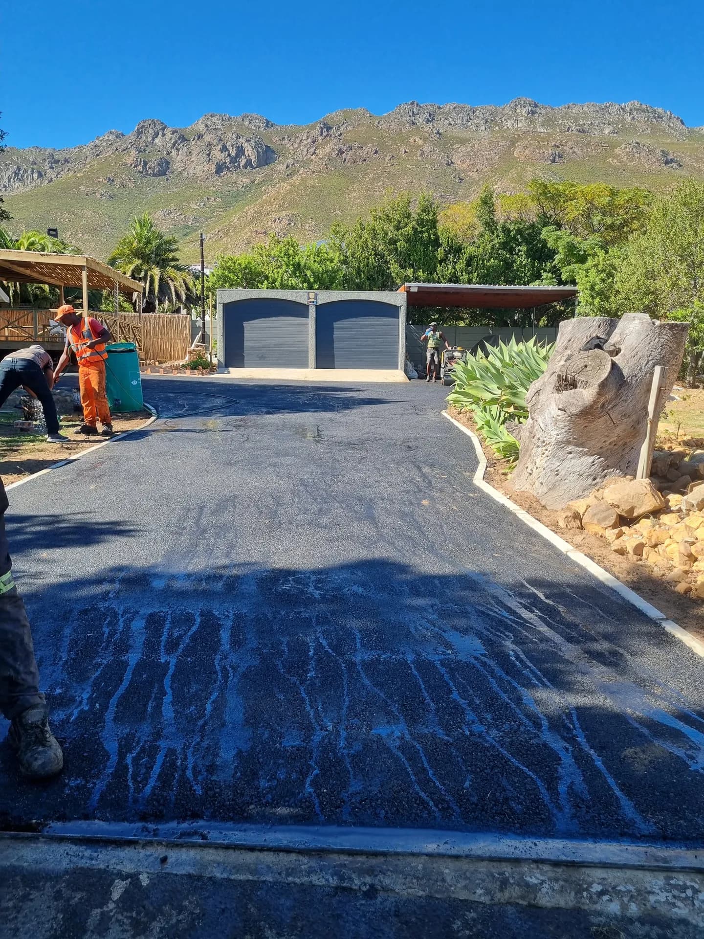 New asphalt driveway leading to a double garage